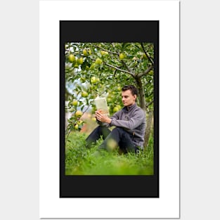 Teenager reading a book in the orchard Posters and Art